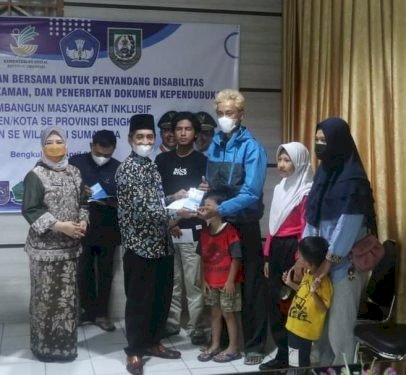 Kepala Dinas Dukcapil Kota Bengkulu, Widodo Saat Memberikan Dokumen Adminduk Kepada Beberapa Anak Penyandang Disabilitas/Net