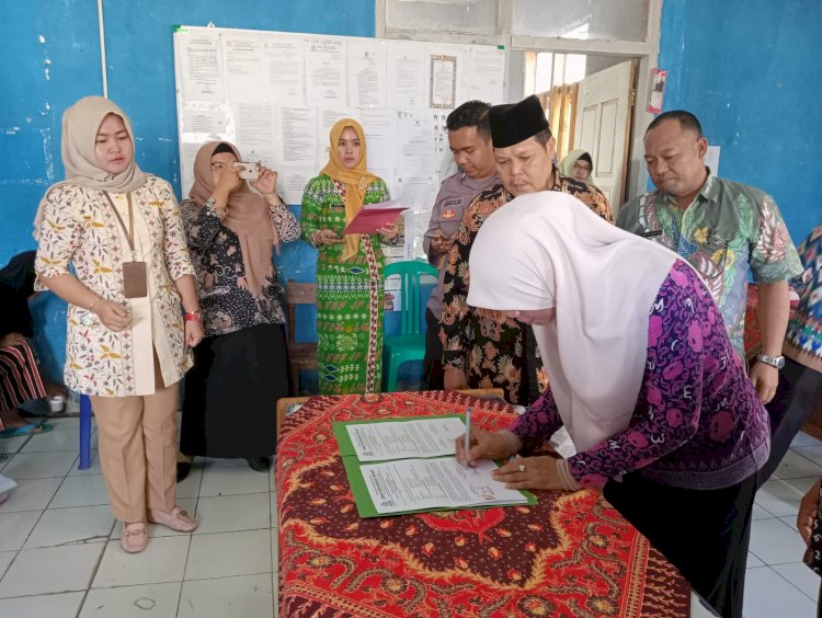 Kadis Ketahanan Pangan Kabupaten Lebong, Tina Herlina saat menandatangani berita acara penyerahan bantuan cadangan pangan kepada 40 KK di Kecamatan Topos/RMOLBengkulu