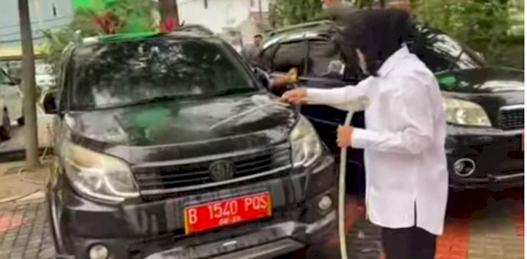 Potongan video Mensos Tri Rismaharini sedang mencuci sebuah mobil dinas/ Repro